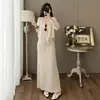 Conjunto de tricô casual de duas peças com decote V para mulheres, apresentando um top folgado de mangas compridas e uma saia longa de cintura alta e fluida, criando um look elegante e estiloso.