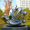 Esculturas de acero inoxidable a gran escala, hechas a medida para jardines urbanos exteriores, con diseños circulares abstractos espejados, sirviendo como hitos metálicos icónicos y elementos decorativos