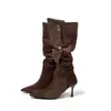 Sin embargo, estas son botas vaqueras de tacón alto de gamuza estilo retro para mujer, que llegan hasta la rodilla, con punta fina, tacón delgado y detalle de hebilla metálica.