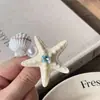 Pinza para el pelo con forma de estrella de mar y concha de perla, estilo resort costero, incrustada de diamantes, sensación de lujo ligero y alta gama, accesorio de moda para el cabello para mujer
