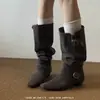 No entanto, o novo estilo de botas de cavaleiro apresenta um cano largo, uma fivela de cinto de couro, um acabamento em camurça, um efeito emagrecedor, um salto grosso, uma biqueira quadrada e um comprimento até a panturrilha.