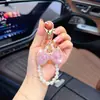 Llavero de lazo de moda con diamantes completos y cadena de perlas, un colgante lindo y brillante para bolsos, cadenas de teléfono y accesorios