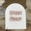 Un Diseño de Uñas Estilo Chica Dulce con Flores Rosas y Tiernas Talladas a Mano y Base Transparente, Presentando un Diseño de Flor Seca