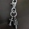O novo chaveiro de pingente duplo da Yanyu apresenta uma cruz, âncora, espada em formato de coração e fecho lagosta, oferecendo um design de nicho único e estiloso.
