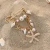 Broche de estrella de mar con perla microincrustada estilo oceánico transfronterizo europeo y americano, pasador de borla de concha de nicho, accesorio de ropa versátil