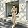 Moda de principios de otoño: un conjunto completo de dos piezas puro y seductor para mujer que presenta un top tipo dos piezas falso y pantalones de pierna ancha, creando un look elegante y chic