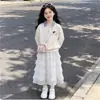 Conjunto versátil de top xadrez com retalhos e gola alta e saia de cor sólida com renda, estilo preppy para meninas, novidades da primavera e outono de 2026