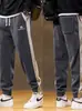 Calça de moletom esportiva masculina da moda para primavera, versátil, de corte solto, novas calças jogger de corte justo com cores contrastantes, calças casuais