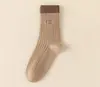 Colección de otoño: Calcetines de mujer elegantes y modernos en una paleta de colores Maillard, con diseños de rayas, letras y de longitud larga, perfectos para uso casual y versátiles para cualquier atuendo en otoño e invierno.