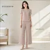 Conjunto plissado estampado floral de verão para mulheres, apresentando calça cropped plissada de seda gelada e um top de gola redonda e corte solto, perfeito para uso casual em casa