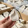 Bolsa de cordón de textura suave, bolsa de tela satinada color beige con logotipo estampado en lámina dorada, fábrica de bolsas de cordón de satén de seda de alta gama