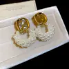 Pendientes de borla de flor de concha blanca transfronterizos europeos y americanos con perlas, pendientes de estilo de corte francés, pendientes ligeros y lujosos con un toque de alta gama