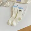 Meias de Cano Médio Bordadas em Desenho Animado Meias com Etiqueta de Tecido Listradas em Creme e Azul para Mulheres Outono e Inverno Novas Meias Slouch de Algodão Penteado com Agulha Dupla
