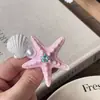 Pinza para el pelo con forma de estrella de mar y concha de perla, estilo resort costero, incrustada de diamantes, sensación de lujo ligero y alta gama, accesorio de moda para el cabello para mujer