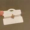 Pulsera giratoria de trébol de cuatro hojas rosa con micro incrustaciones de oro electrochapado 2023 nueva pulsera minimalista de cuerda para la mano de circón J462