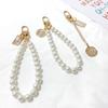 Versión coreana de cadena de perlas para cabeza de belleza retro llavero anillos para llaves redondos con letras para mujer adornos para bolso pequeños regalos al por mayor