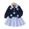 Atacado transfronteiriço de roupas para meninas: camisas com estampas florais, saias curtas listradas e blusas estilo preppy