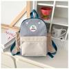 Mochila Infantil 2026 Nova Coreana Fofa Color Block Mochila Escolar para Jardim de Infância Letras Estampadas Mochila de Bebê Atacado