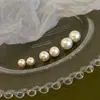 Os populares brincos de prata de lei S999 da Yinjia com pérolas brancas australianas, apresentando um design único e um estilo romântico francês sofisticado.