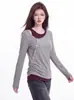 Foto real de la nueva colección de otoño 2026: elegante top de capa base de manga larga, de dos piezas con bloques de color, asimétrico e increíblemente hermoso para mujer