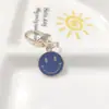 Llavero de cara sonriente de color aleación con goteo transfronterizo de comercio electrónico, accesorios de colgante para bolso con expresión irregular chapado en oro