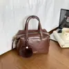 2026 Nuevo Bolso Almohada Boston Estilo Maillard para Mujer Bolso de Mano Retro Bolso de Hombro Cruzado Decoración de Bola de Pelo para Viajes Diarios