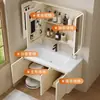 Tocador de baño engrosado y ahorrador de espacio con diseño en color crema, que cuenta con un lavabo redondeado, lavabo cerámico integrado y un lavabo de una sola pieza.